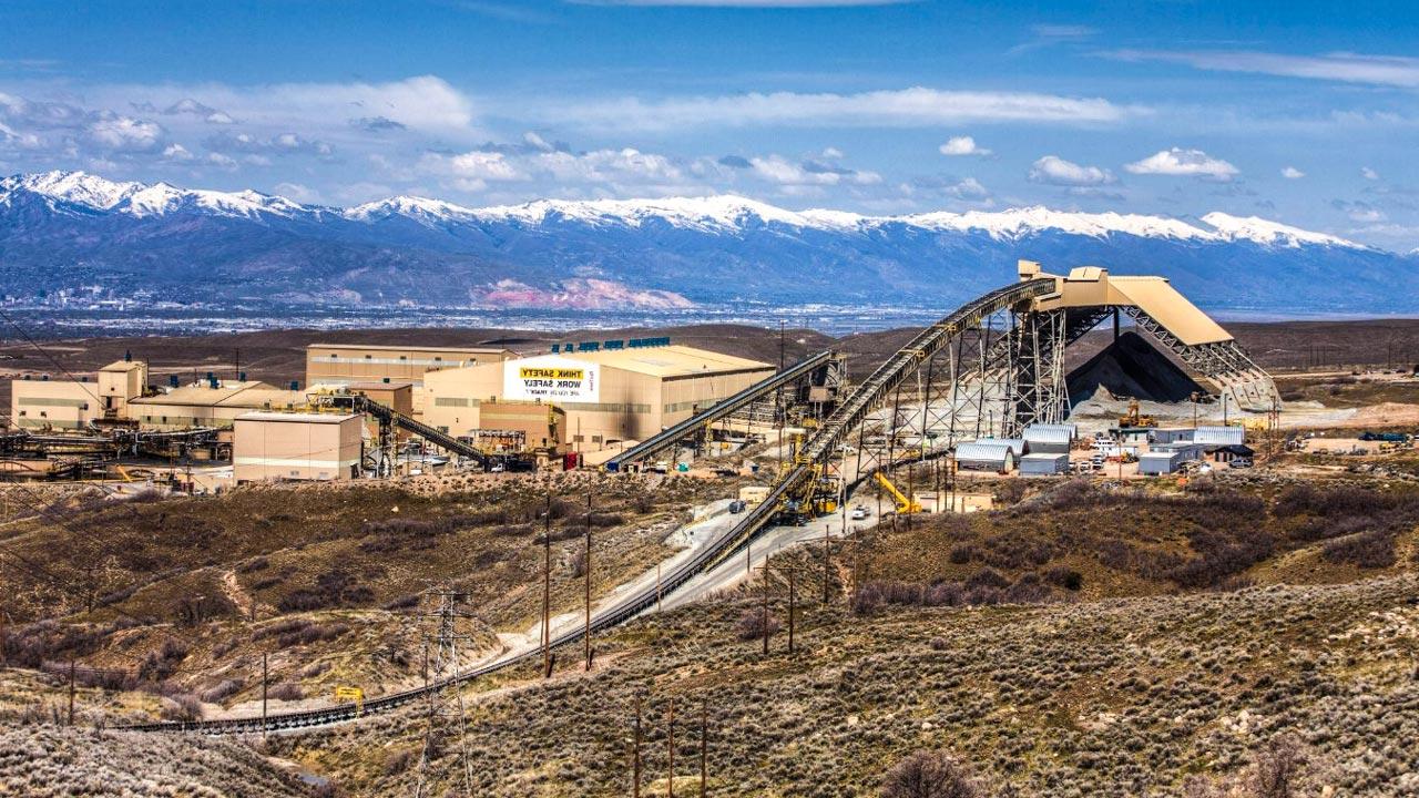 An aerial view of a concentrator plant with mountains and a blue sky in the background